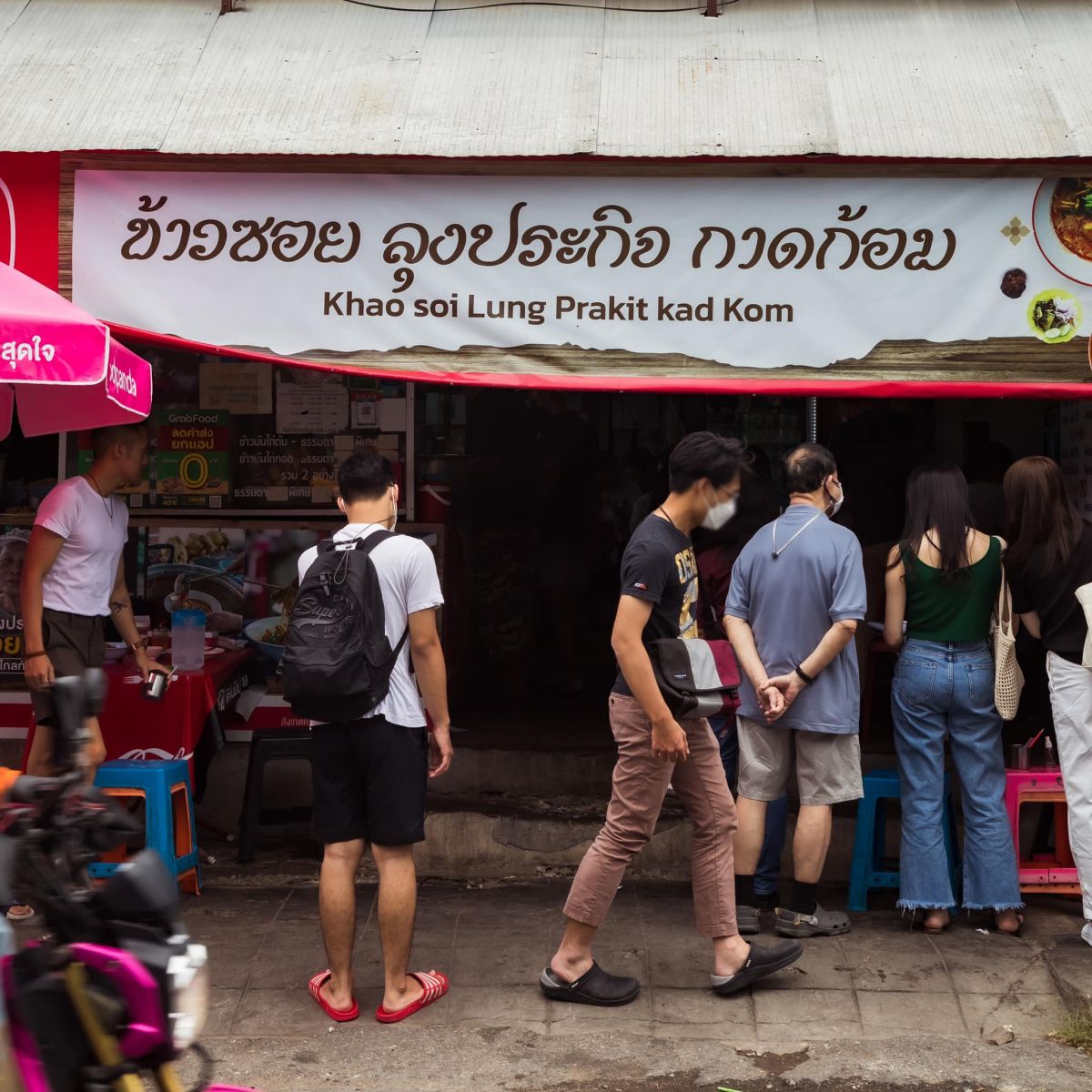 The storefront and Thai and English sign of Khao Soi Lung Prakit Kad Kom in Chiang Mai
